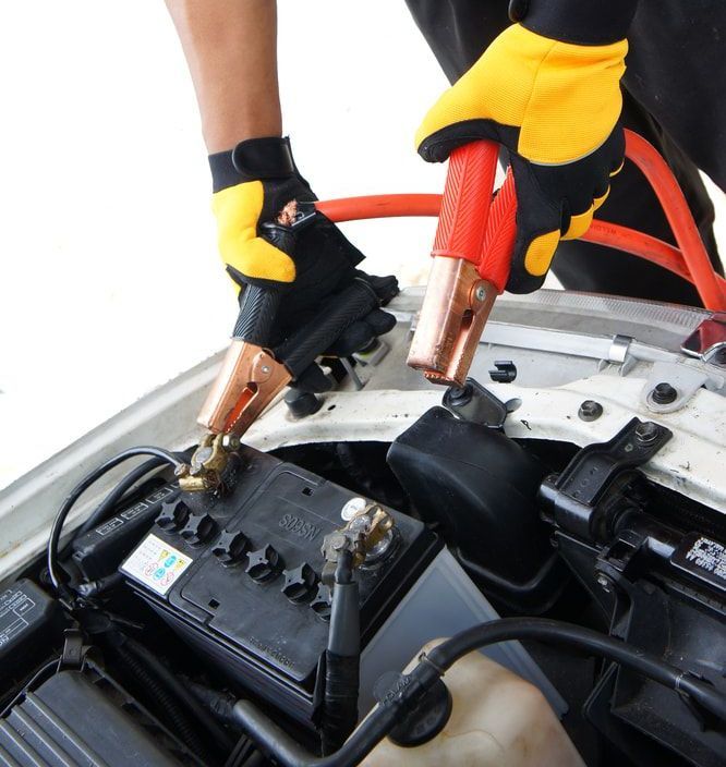 Person Wearing Yellow Gloves is Charging a Car Battery — 365 Towing Taree in Wingham, NSW