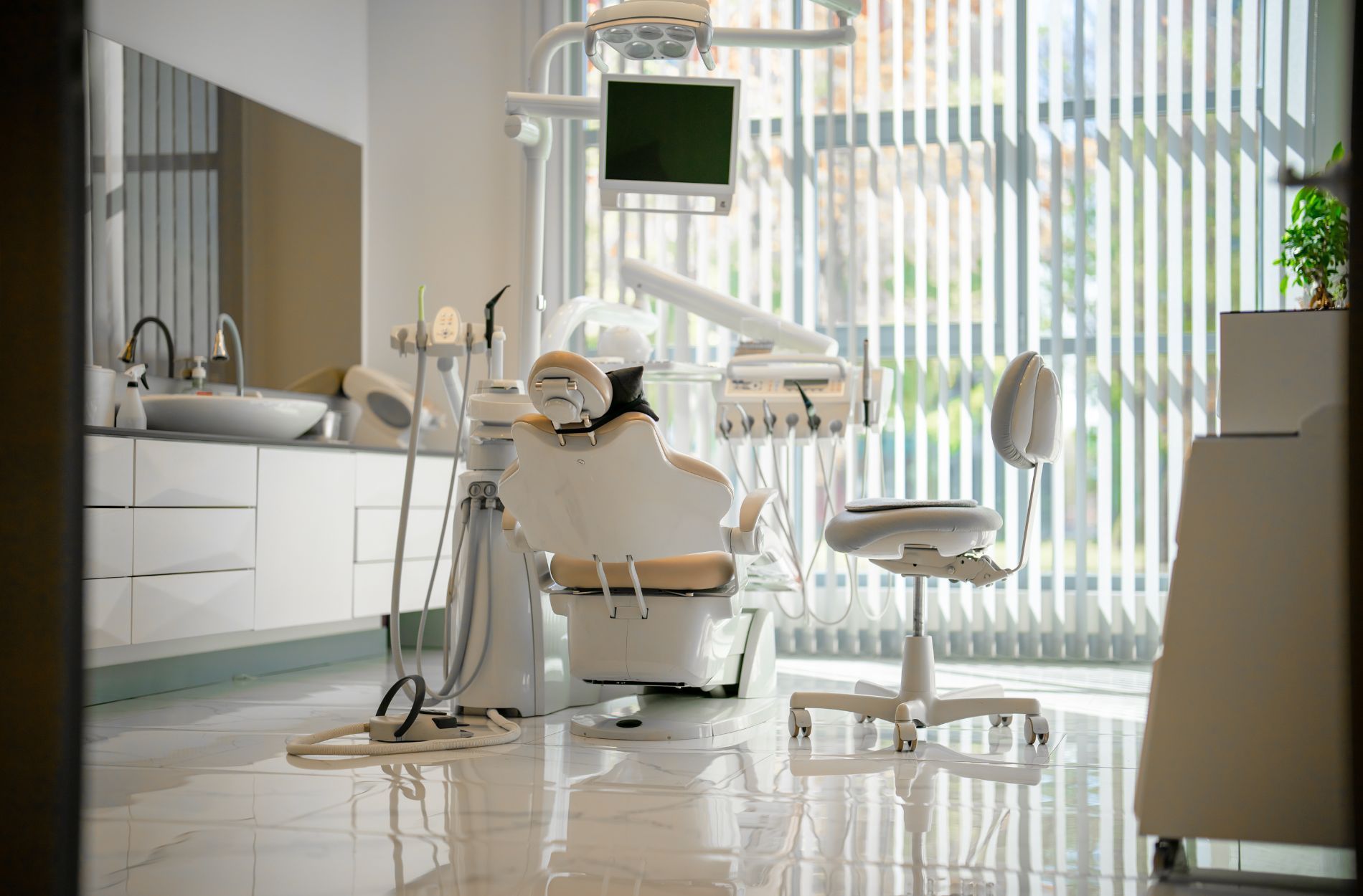 A dental office with a dental chair and a monitor.