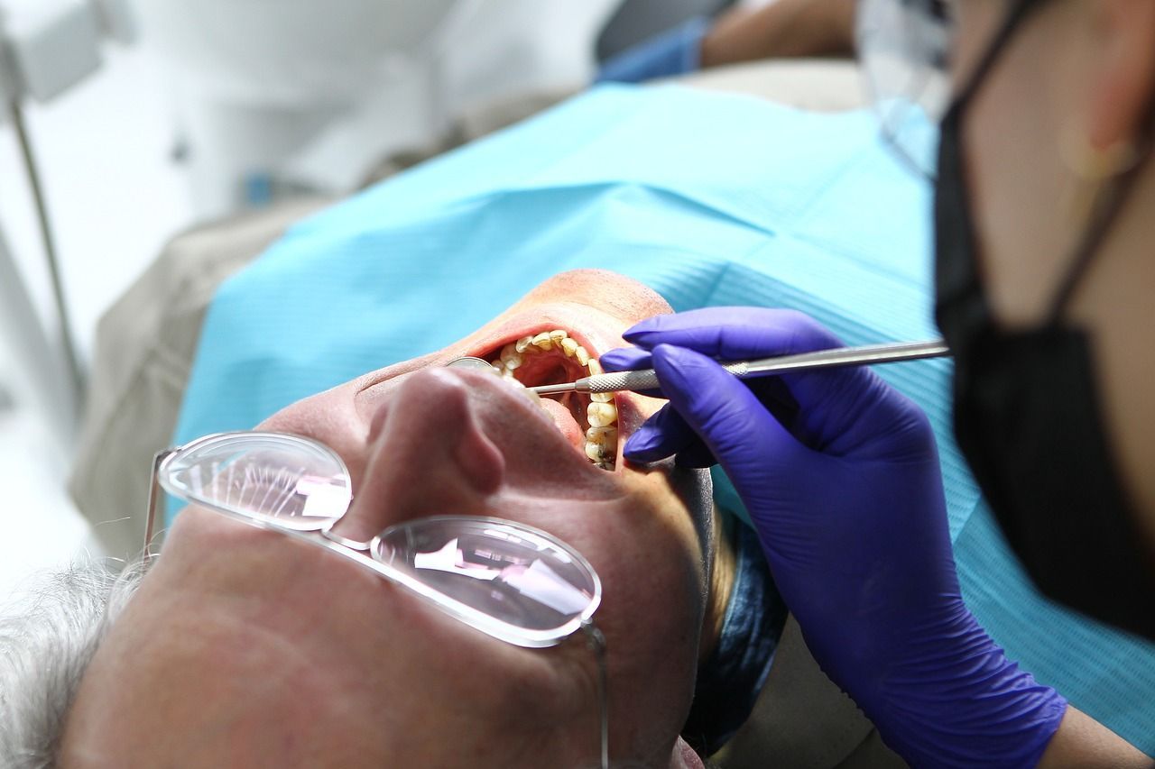 A man is getting his teeth examined by a dentist.