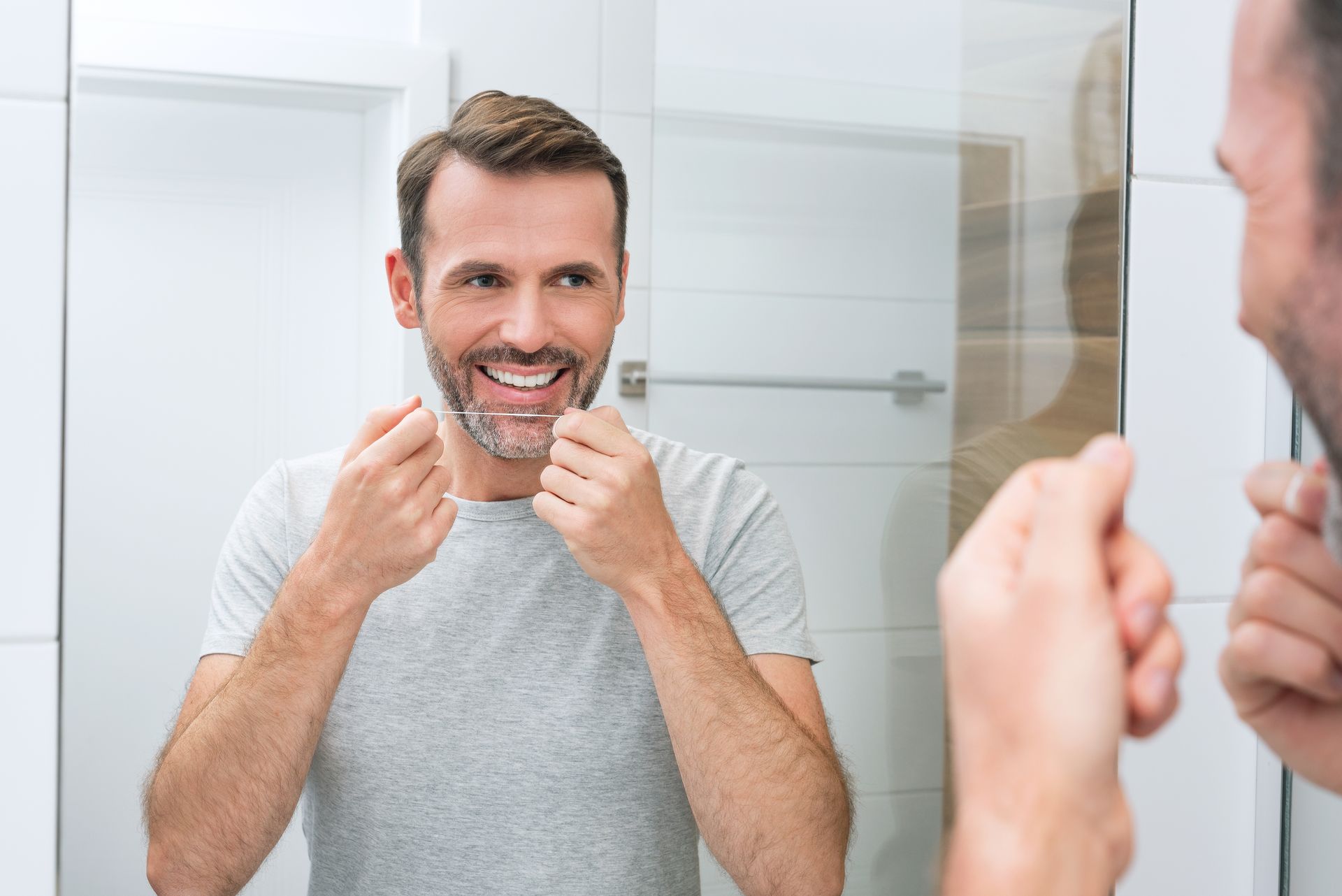 guy cleaning his teeth with dental floss