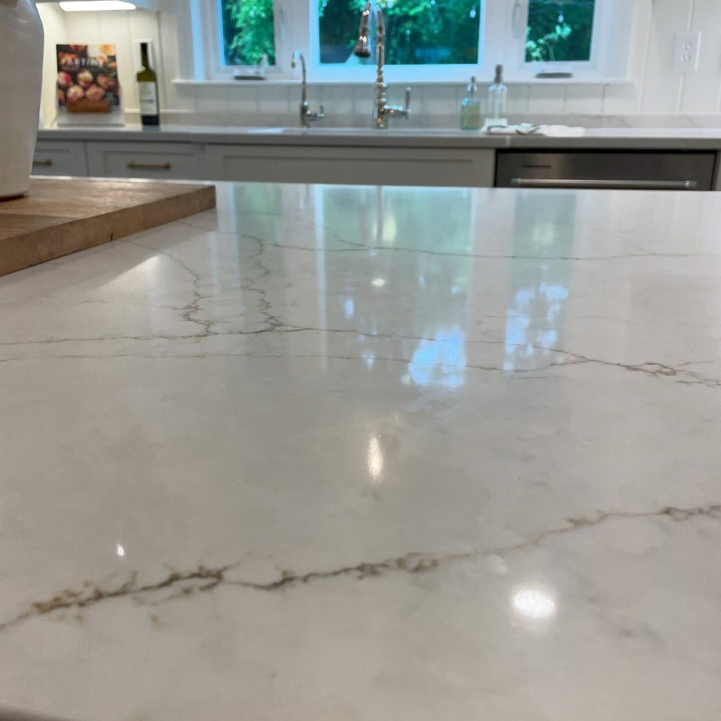 A kitchen counter with a sink and a bottle of wine on it