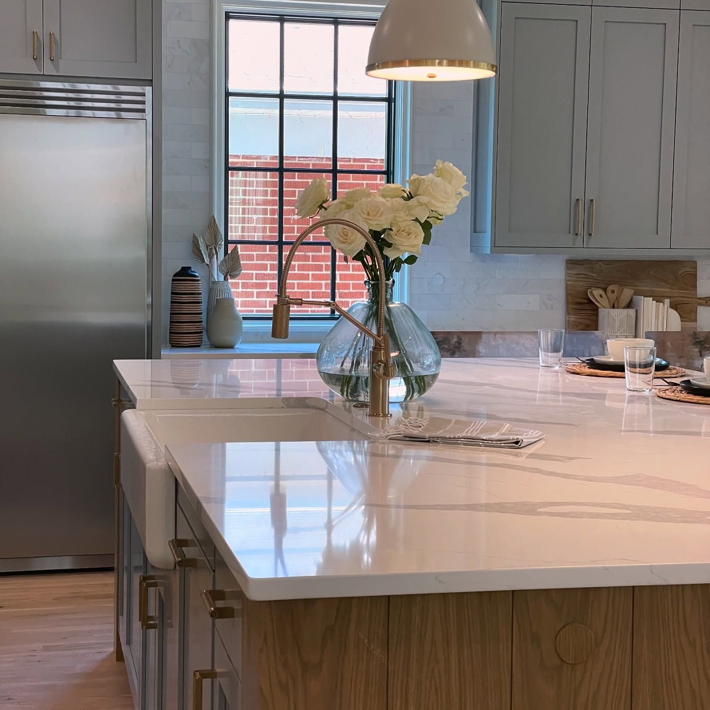 A kitchen with a sink and a vase of flowers on the counter.