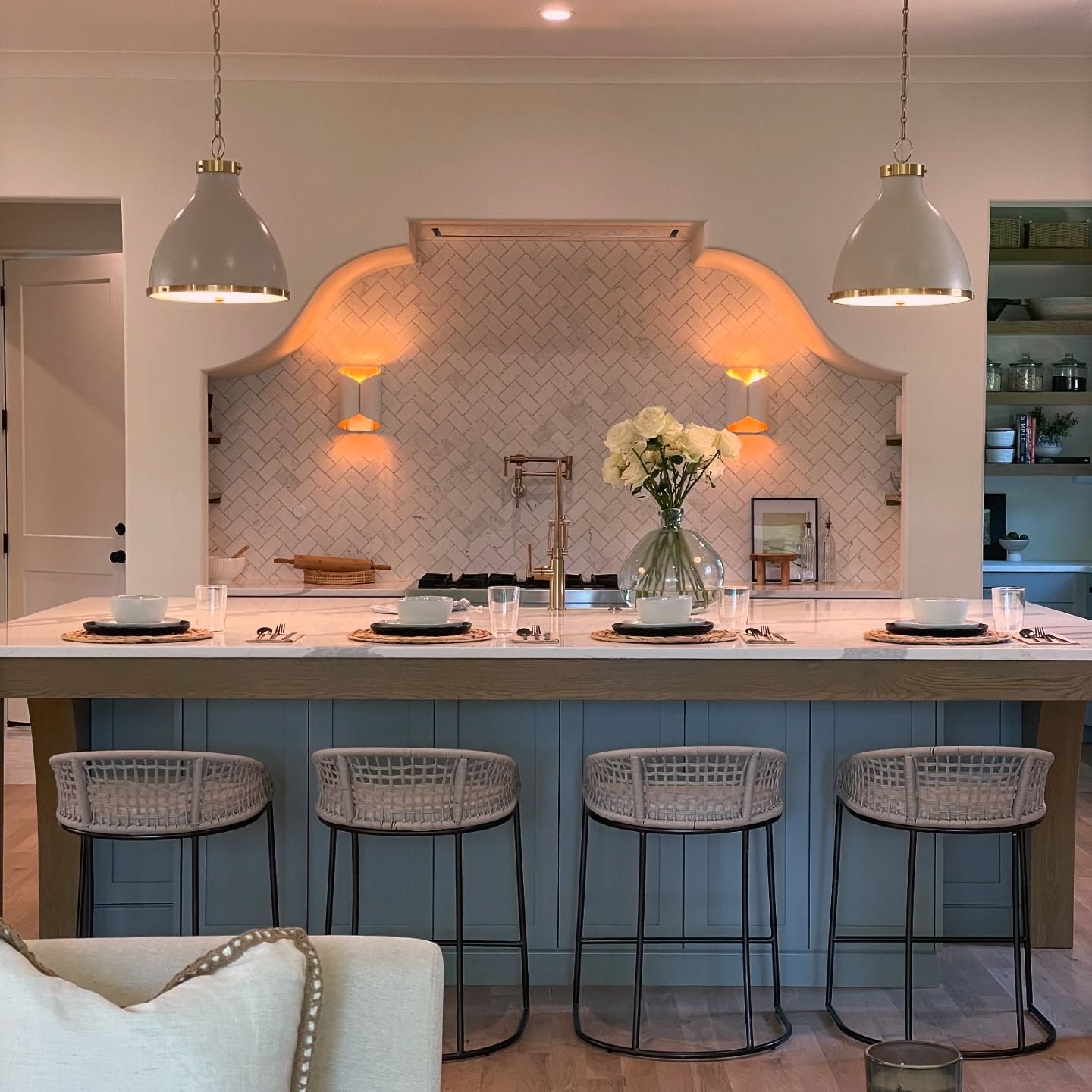 A kitchen with a table and stools and a vase of flowers