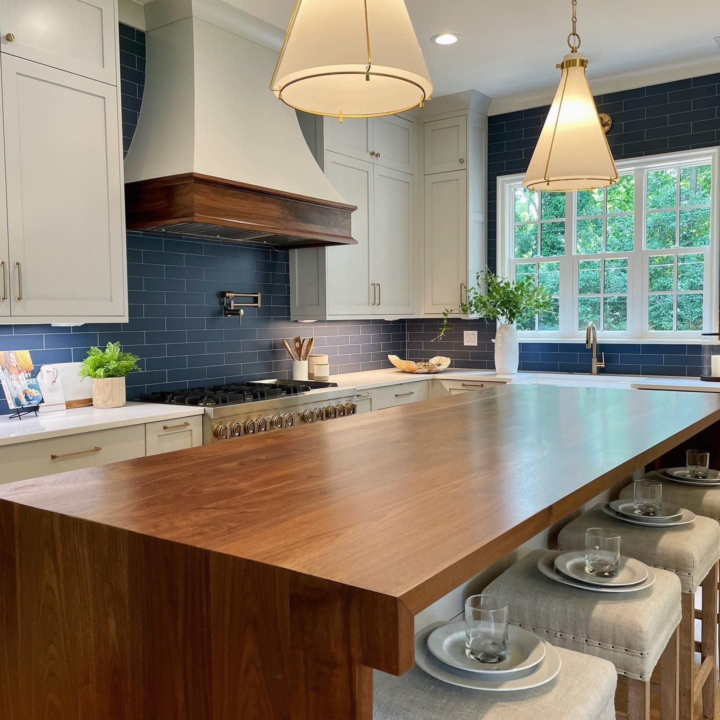 A kitchen with a long wooden table and stools