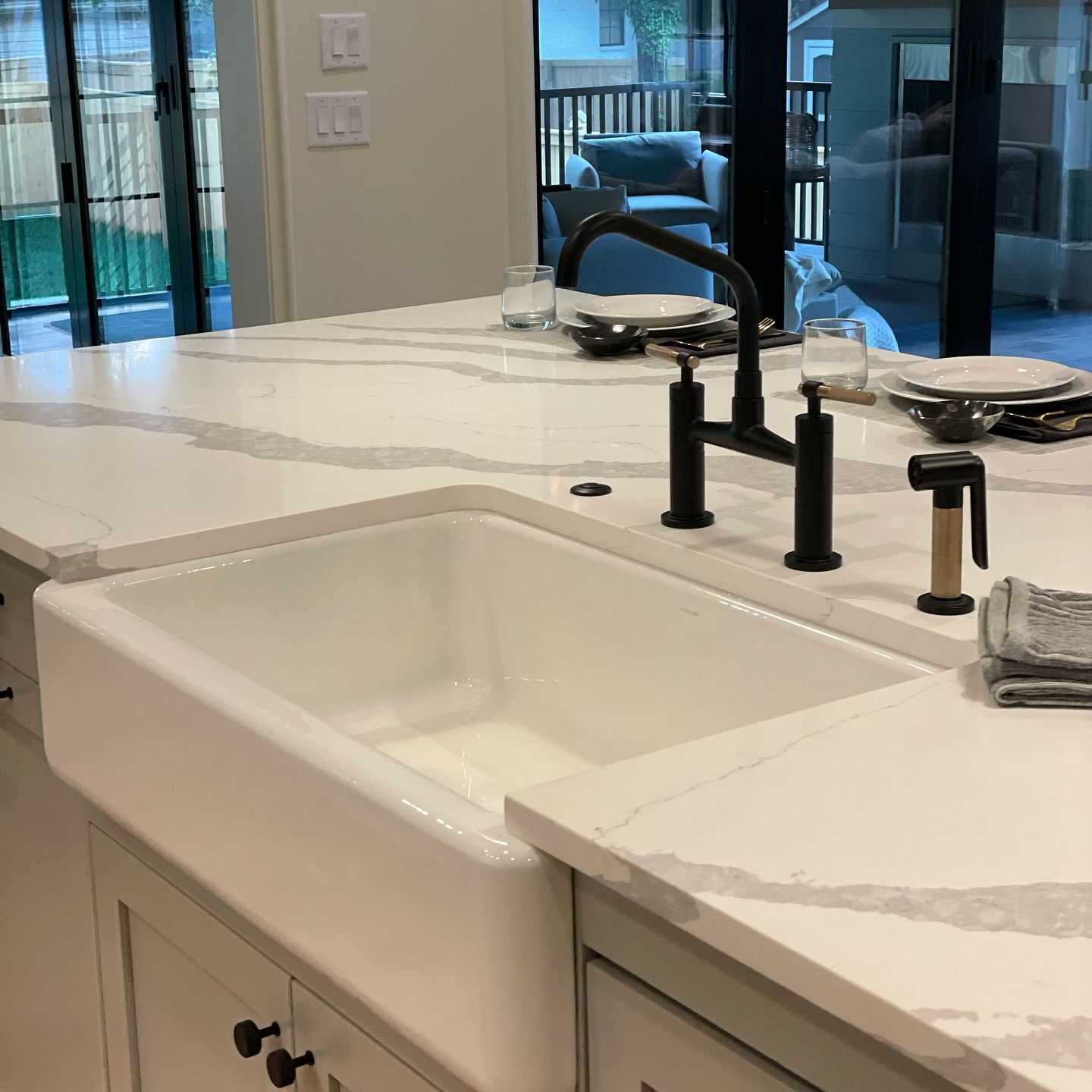 A kitchen with a white sink and a black faucet