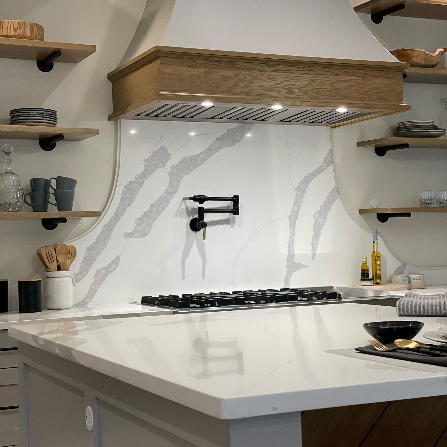 A kitchen with a stove top oven and a wooden hood.