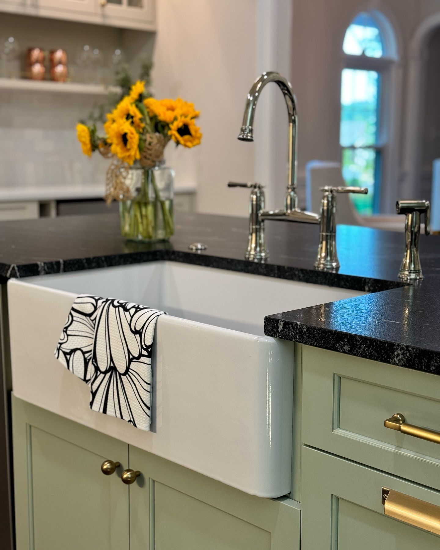A kitchen sink with a floral towel on it