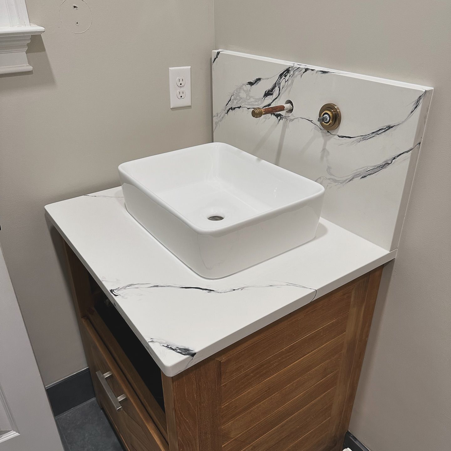 A bathroom sink with a wooden cabinet underneath it