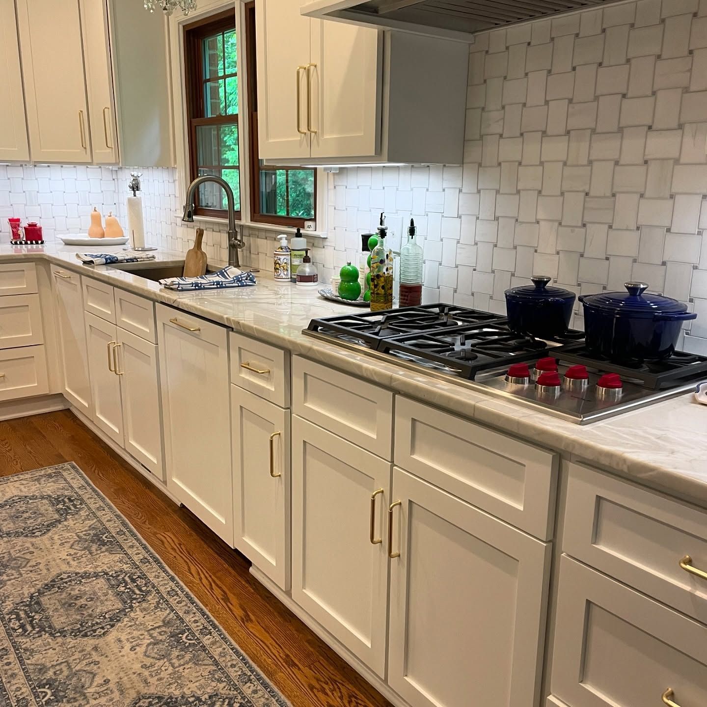 A kitchen with white cabinets and a stove top oven