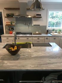 A kitchen with a bowl of fruit on the counter.