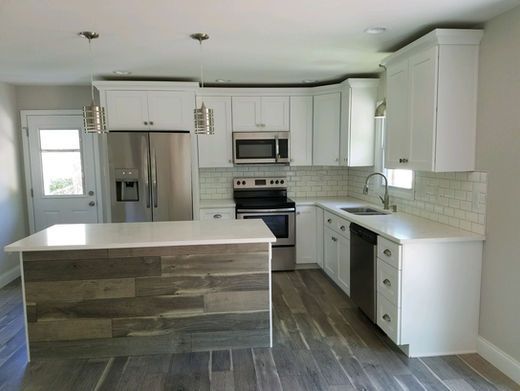A kitchen with white cabinets and stainless steel appliances
