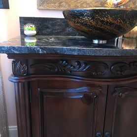 A bathroom vanity with a sink on top of it.