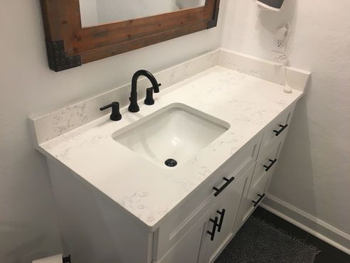 A bathroom vanity with a sink and a mirror.
