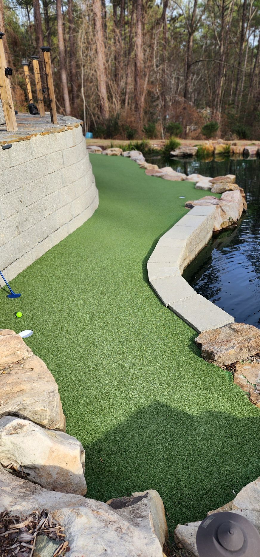 Custom backyard putting green installation with water feature in Raleigh NC