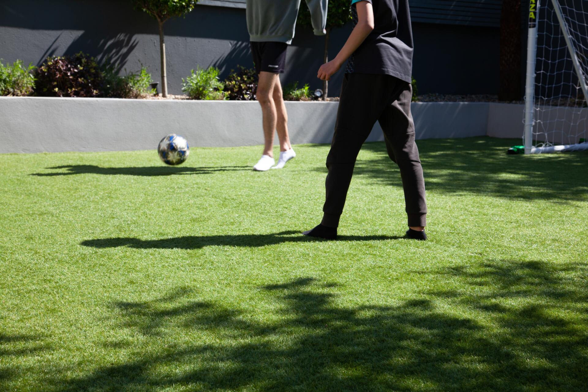 residential artificial turf installation with kids playing soccer in Raleigh