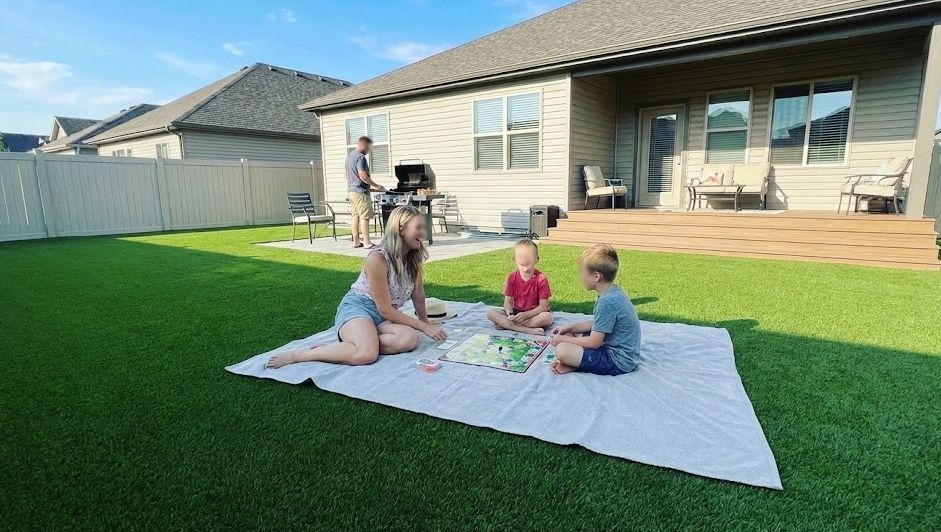 Family enjoying a maintenance-free backyard with residential artificial grass installation.