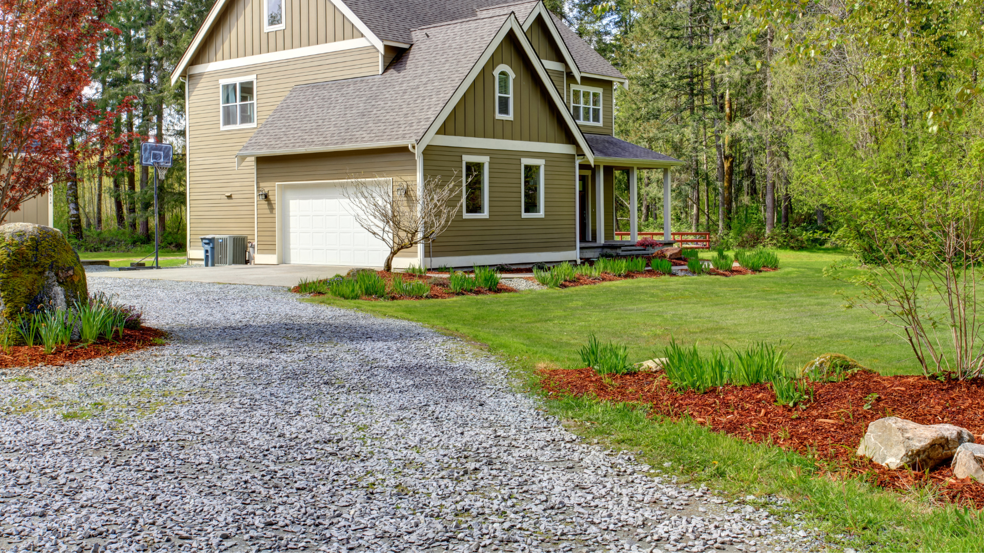 A large house with a gravel driveway in front of it.