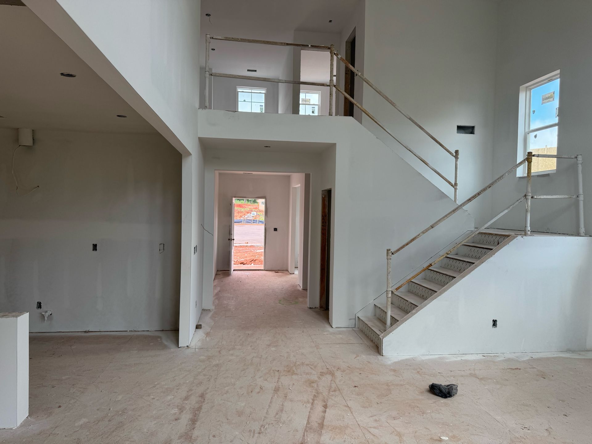 An empty house with stairs going up to the second floor