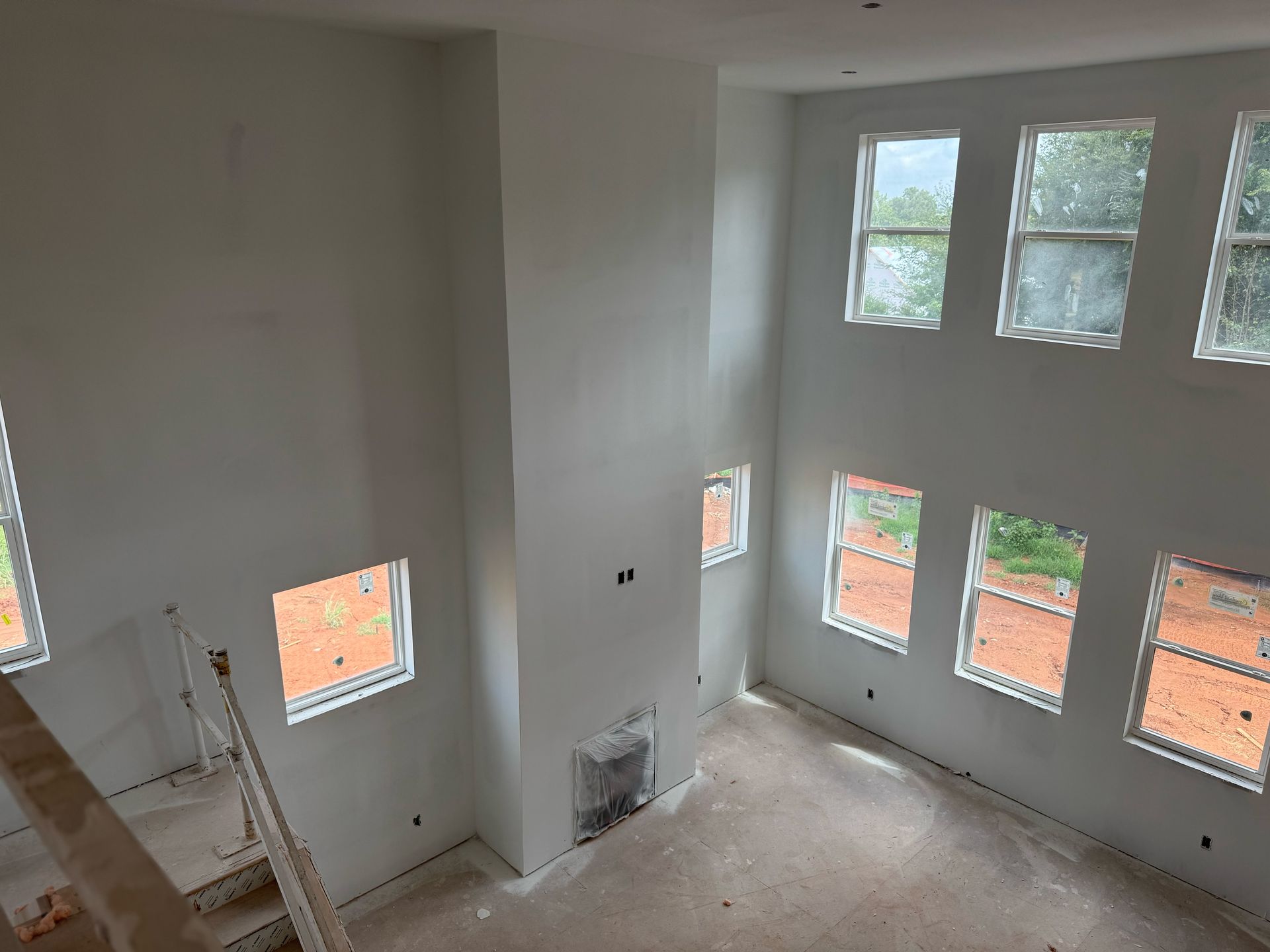 A large room with a lot of windows and a ladder.