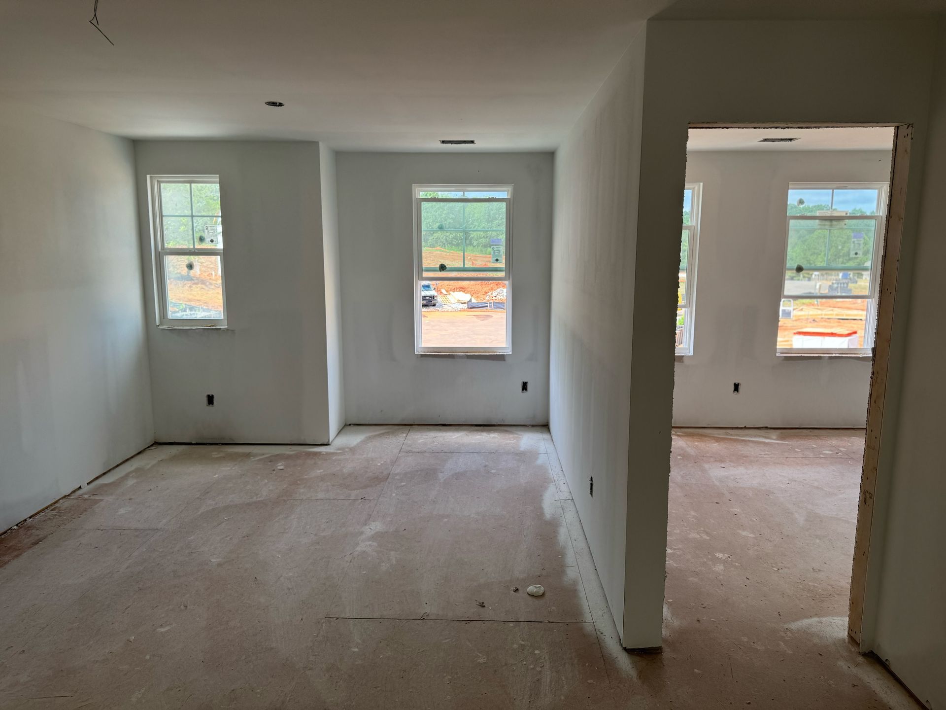 A room with a lot of windows in a house under construction.