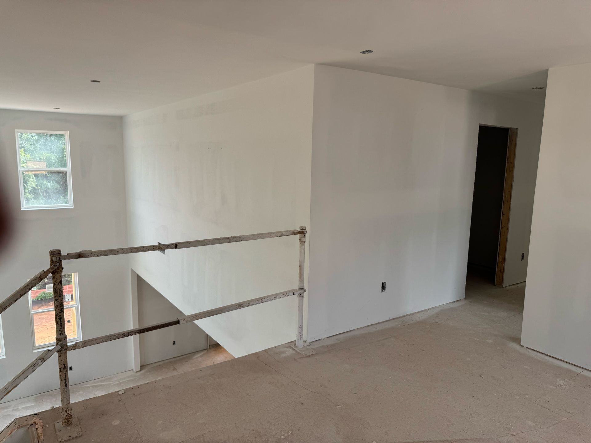 An empty room with a railing and a window.