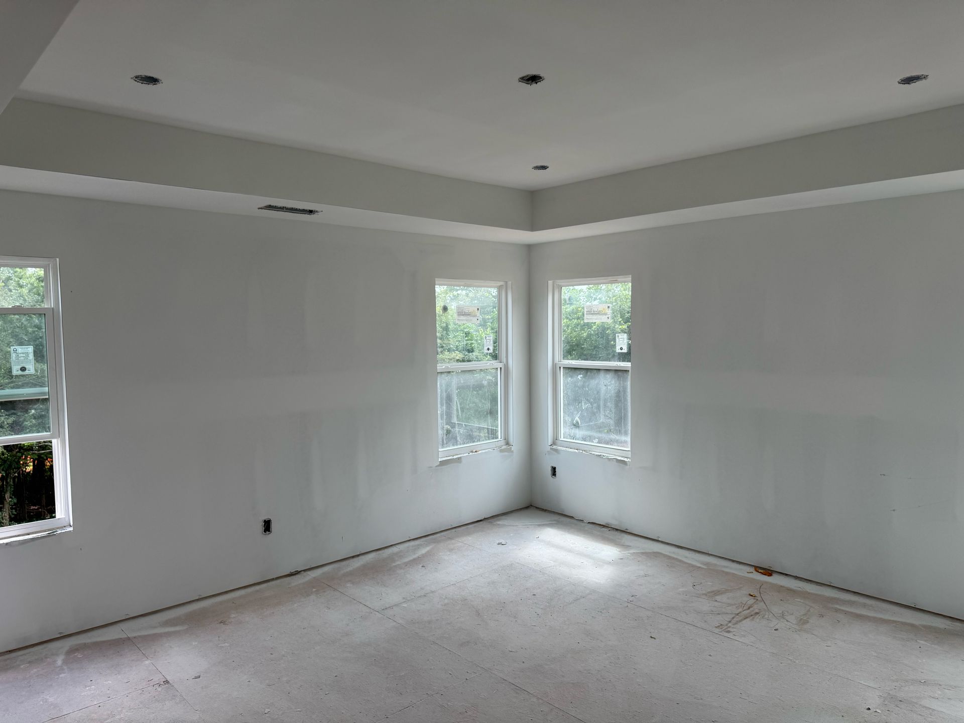 An empty room with a lot of windows and white walls