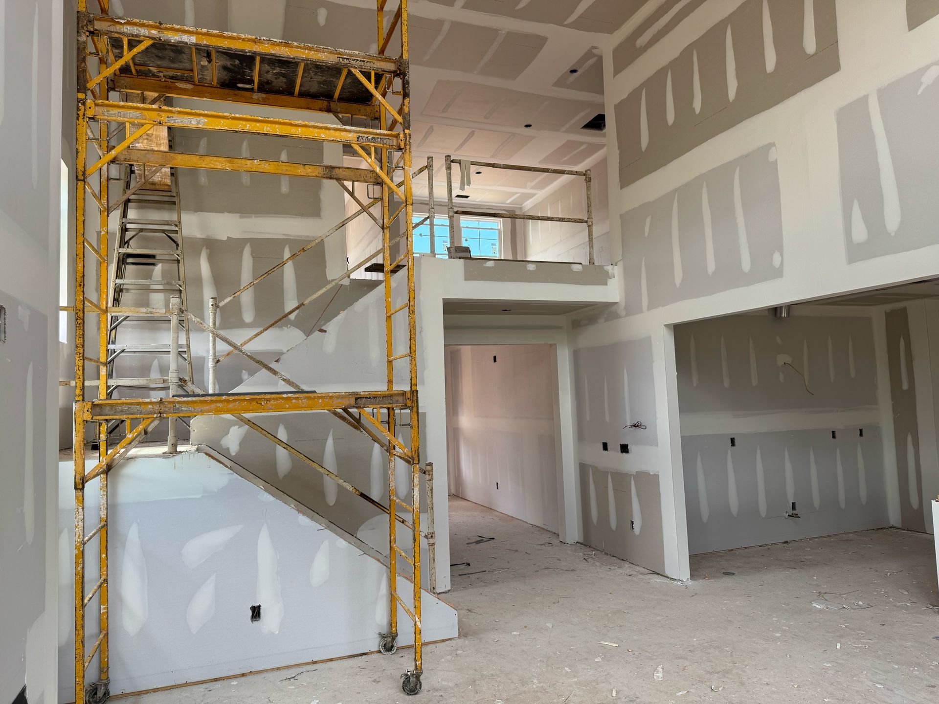 An empty room with a yellow scaffolding in the middle