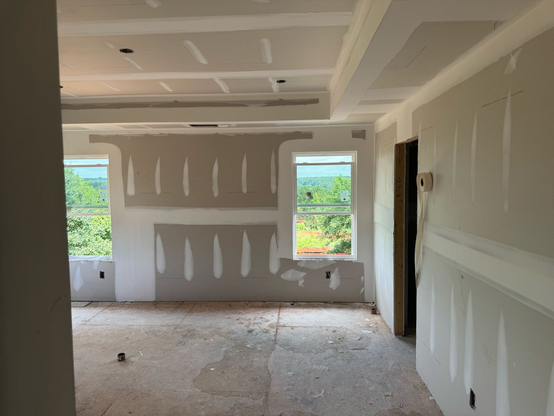 A room with a lot of drywall and a window