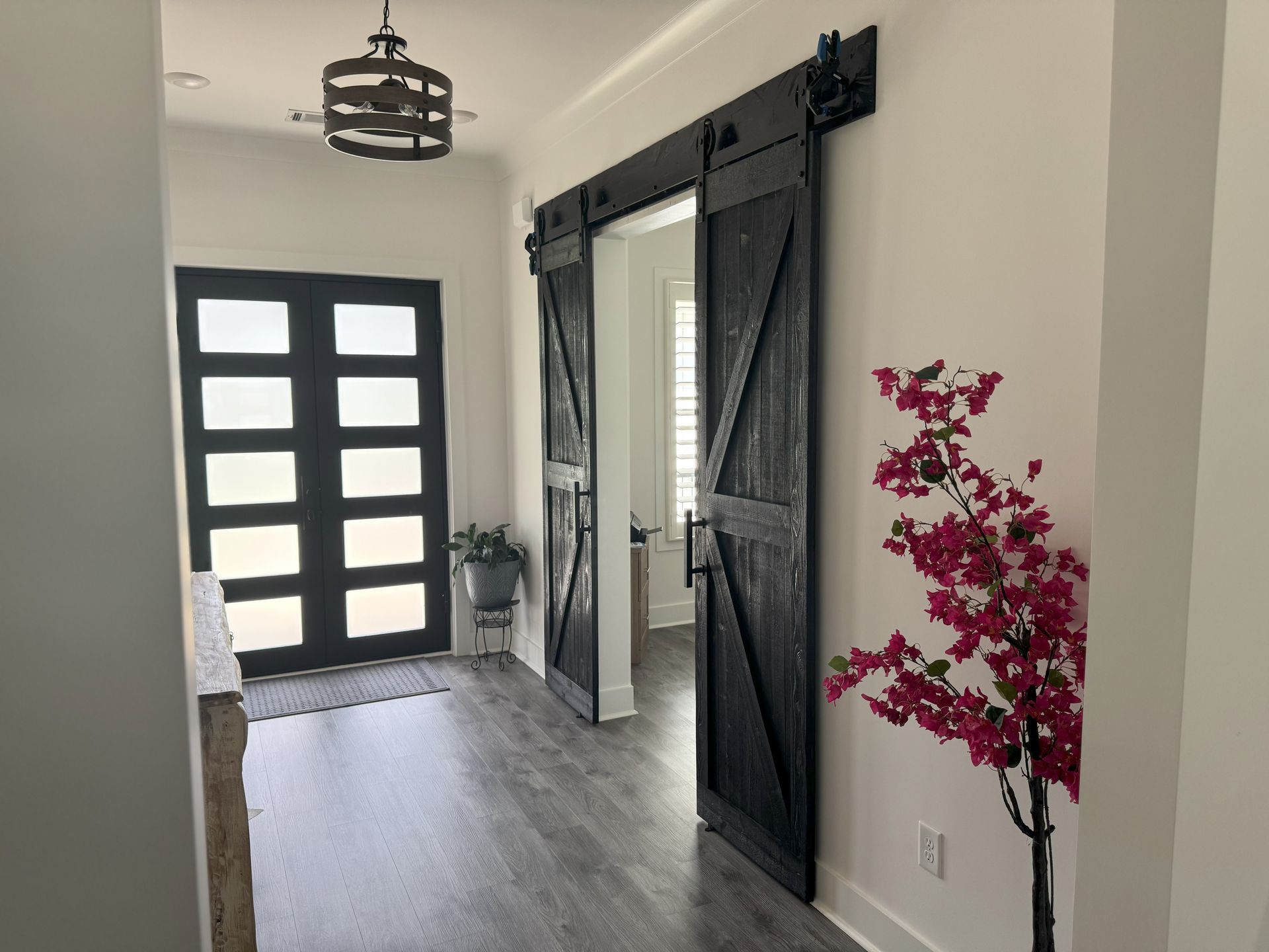 A hallway with sliding barn doors and a pink flower.