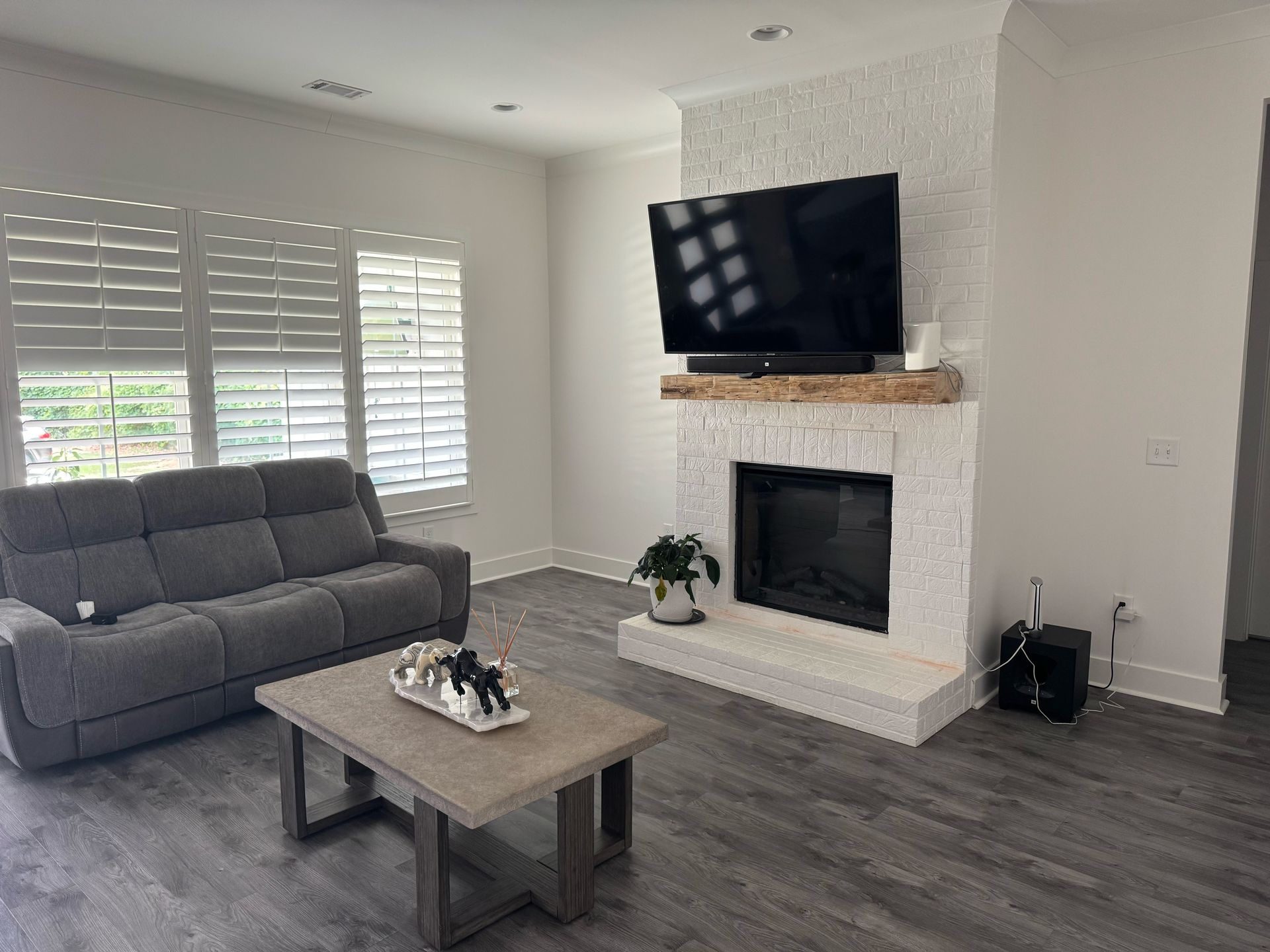 A living room with a couch , coffee table , fireplace and television.