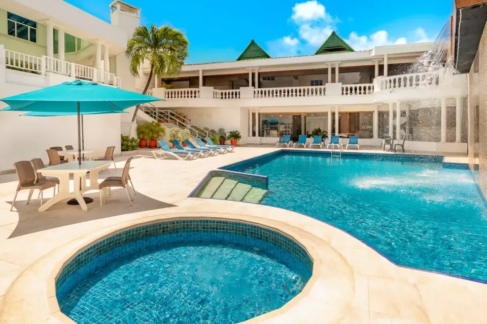Piscina del Hotel Américas SAI San Andrés, rodeada de palmeras y perfecta para relajarse durante tus vacaciones con descuentos especiales.