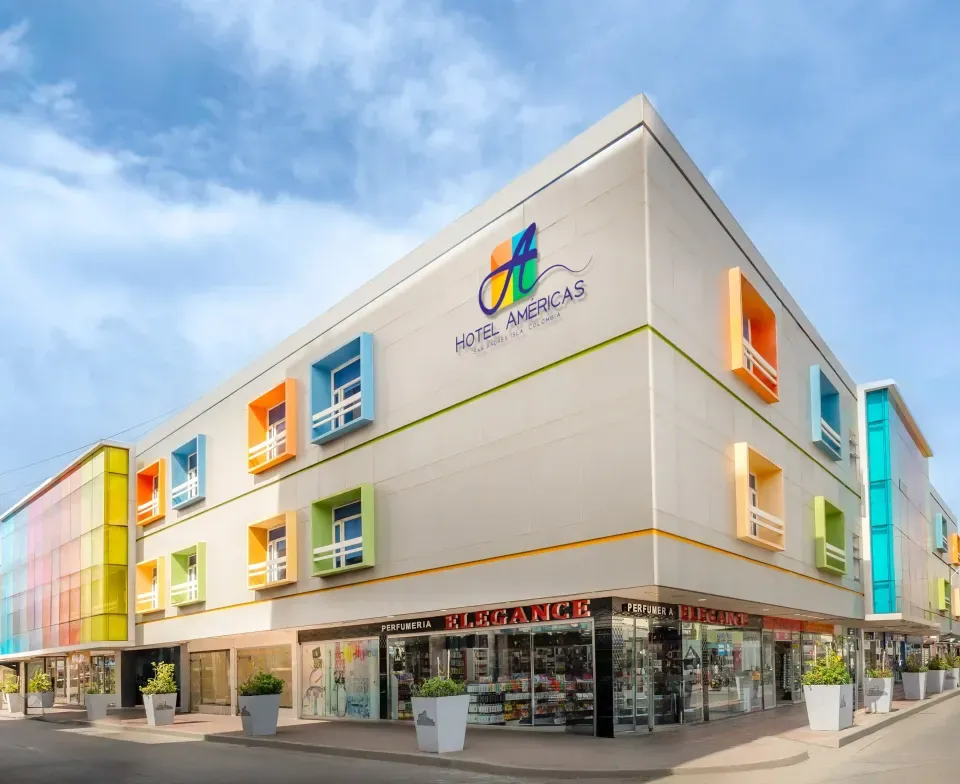 Fachada del Hotel Américas en San Andrés, edificio moderno y colorido ubicado en el centro de la isla cerca de comercios y Playa Spratt Bight.