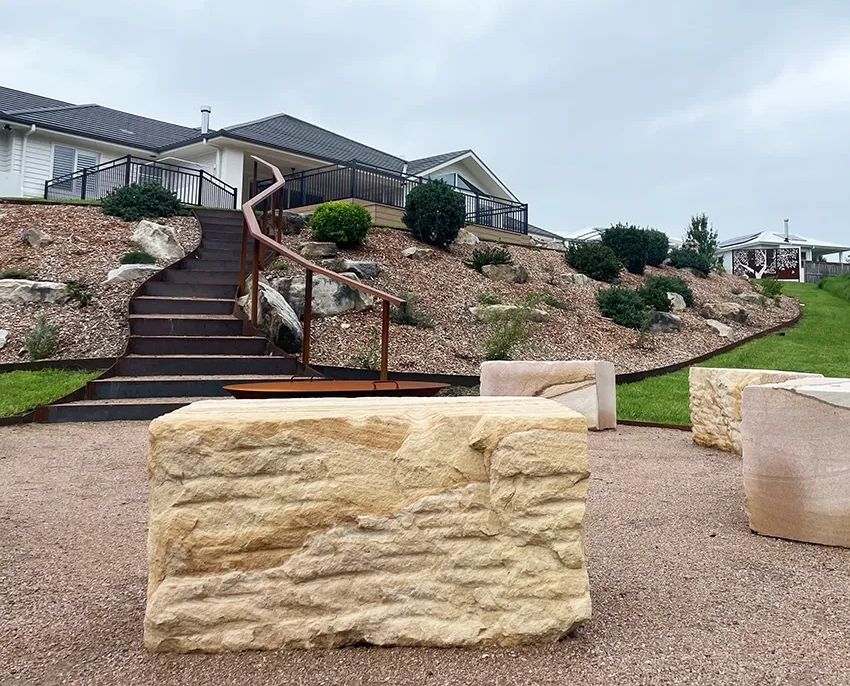 A White House with A Raised Garden Bed in Front Under a Blue Sky — CAW Services in Badagarang, NSW