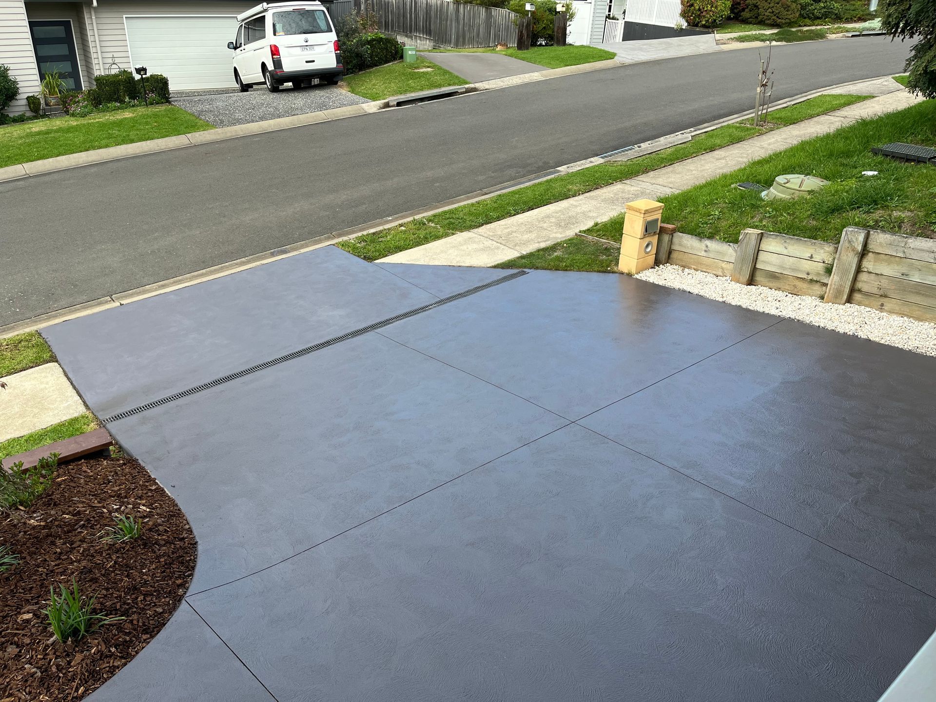 Dark gray concrete driveway with decorative border and street in the background. — CAW Services in Badagarang, NSW