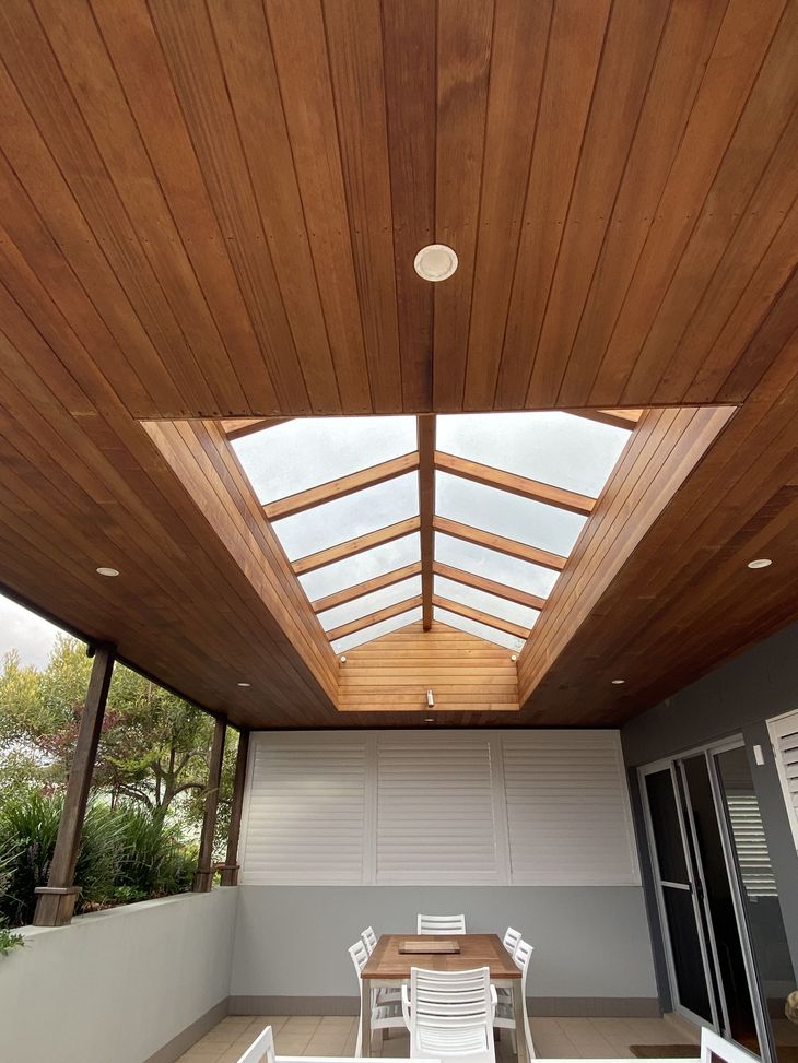 Wooden ceiling with skylight over a patio with a table and chairs. — CAW Services in Badagarang, NSW