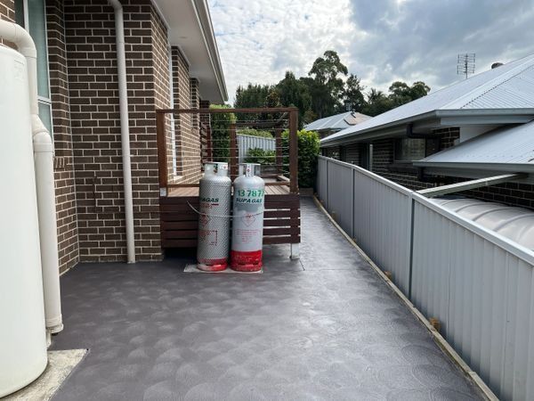 Two Gas Tanks on A Dark Grey Tiled Outdoor Area — CAW Services in Badagarang, NSW