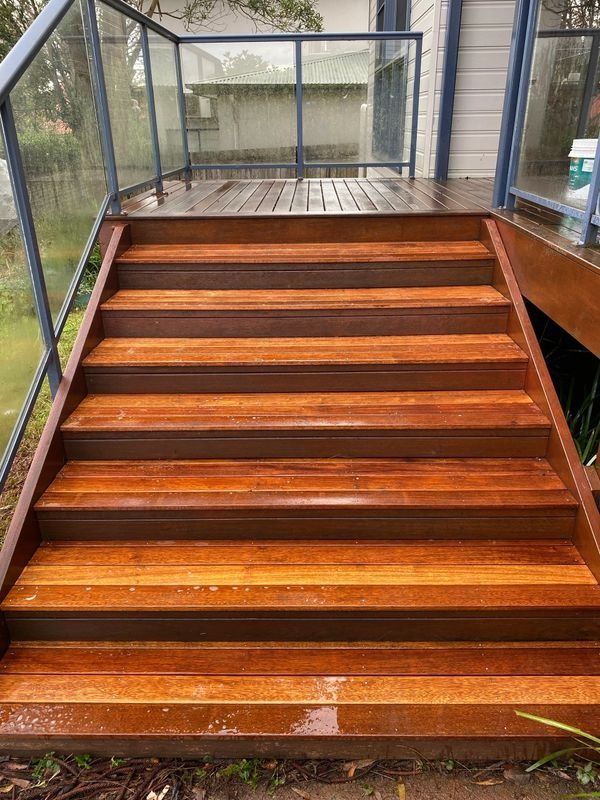 Wooden Outdoor Staircase Leading up To a Deck with Glass Railing — CAW Services in Badagarang, NSW