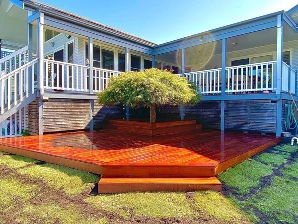 Wooden Deck with Steps Surrounds a Tree in Front of A House — CAW Services in Badagarang, NSW