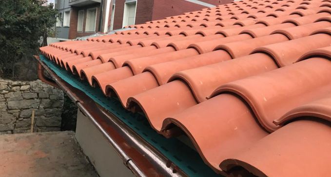 poner canalones con enganches en las tejas en tejado de chalet en Leganés, madrid
