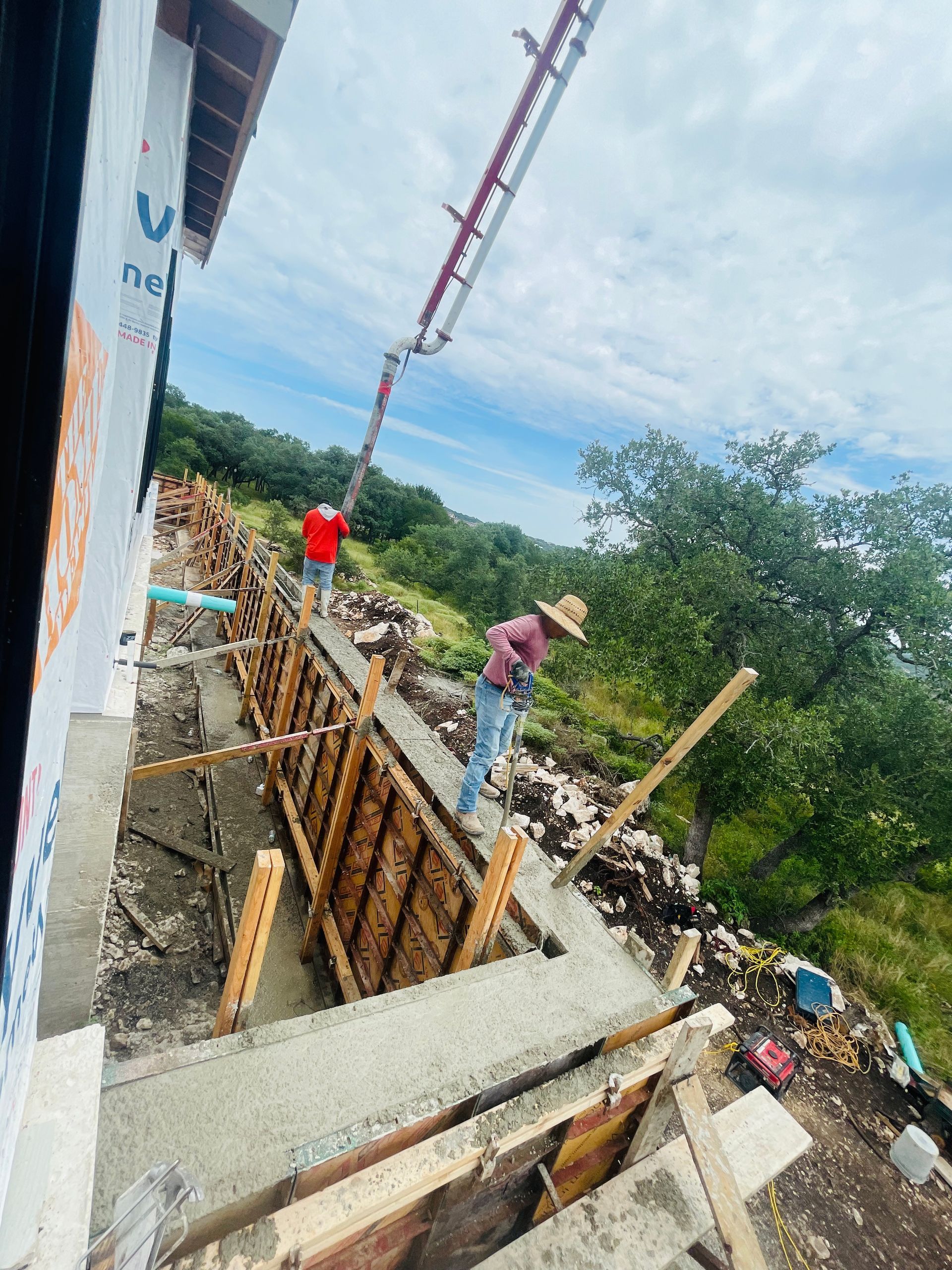 A concrete pump is being used to pour concrete into a wall.