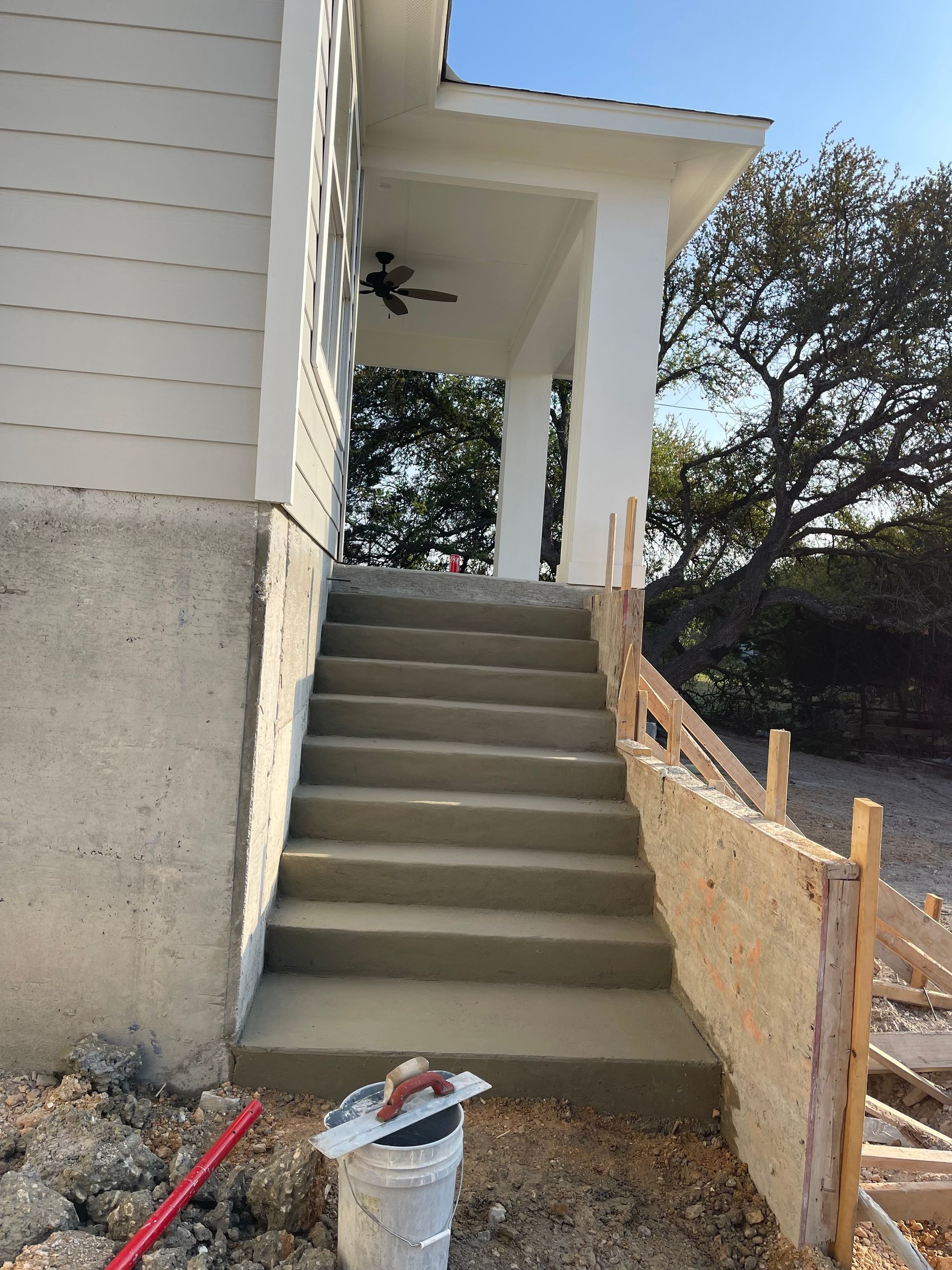 A set of concrete stairs leading up to a porch of a house.