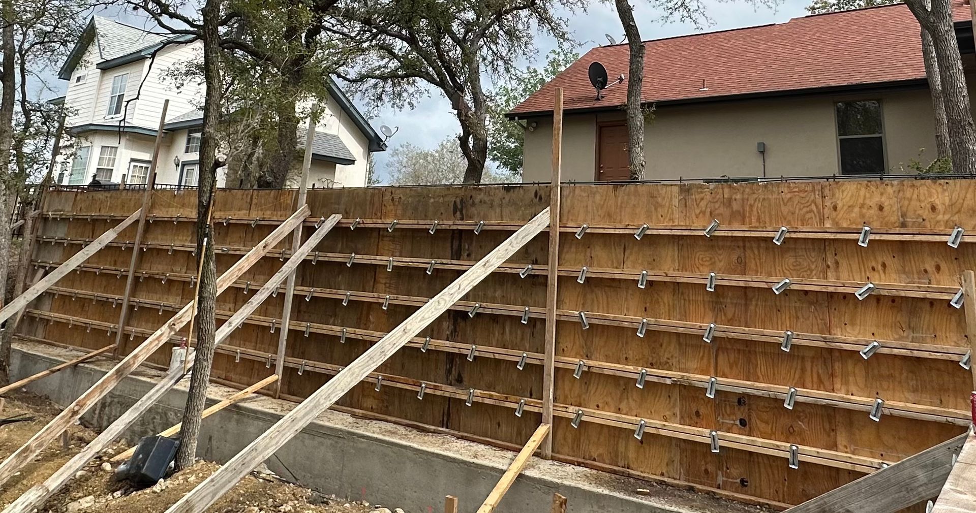 A wooden fence is being built in front of a house.