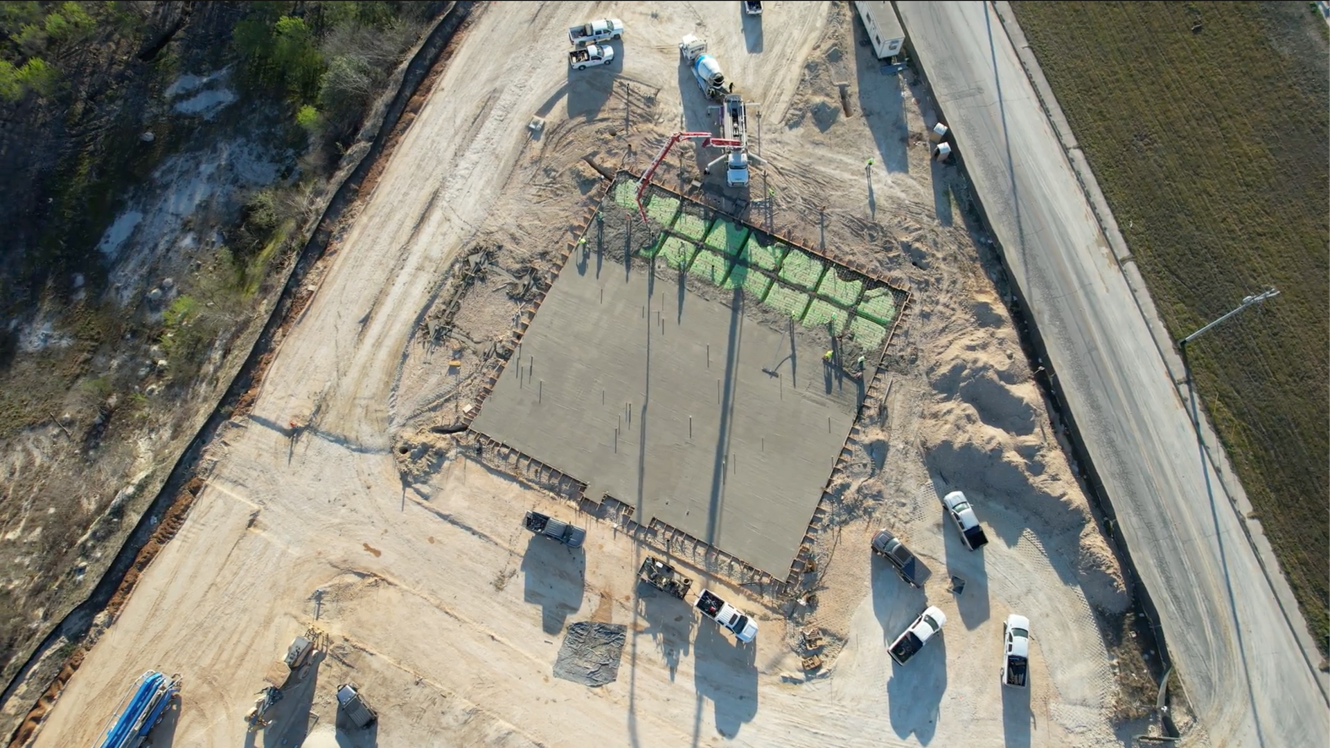 An aerial view of a construction site with trucks and tractors.