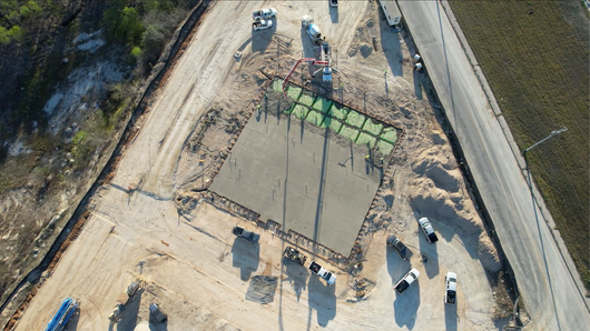 A concrete pump is pouring concrete on a construction site.