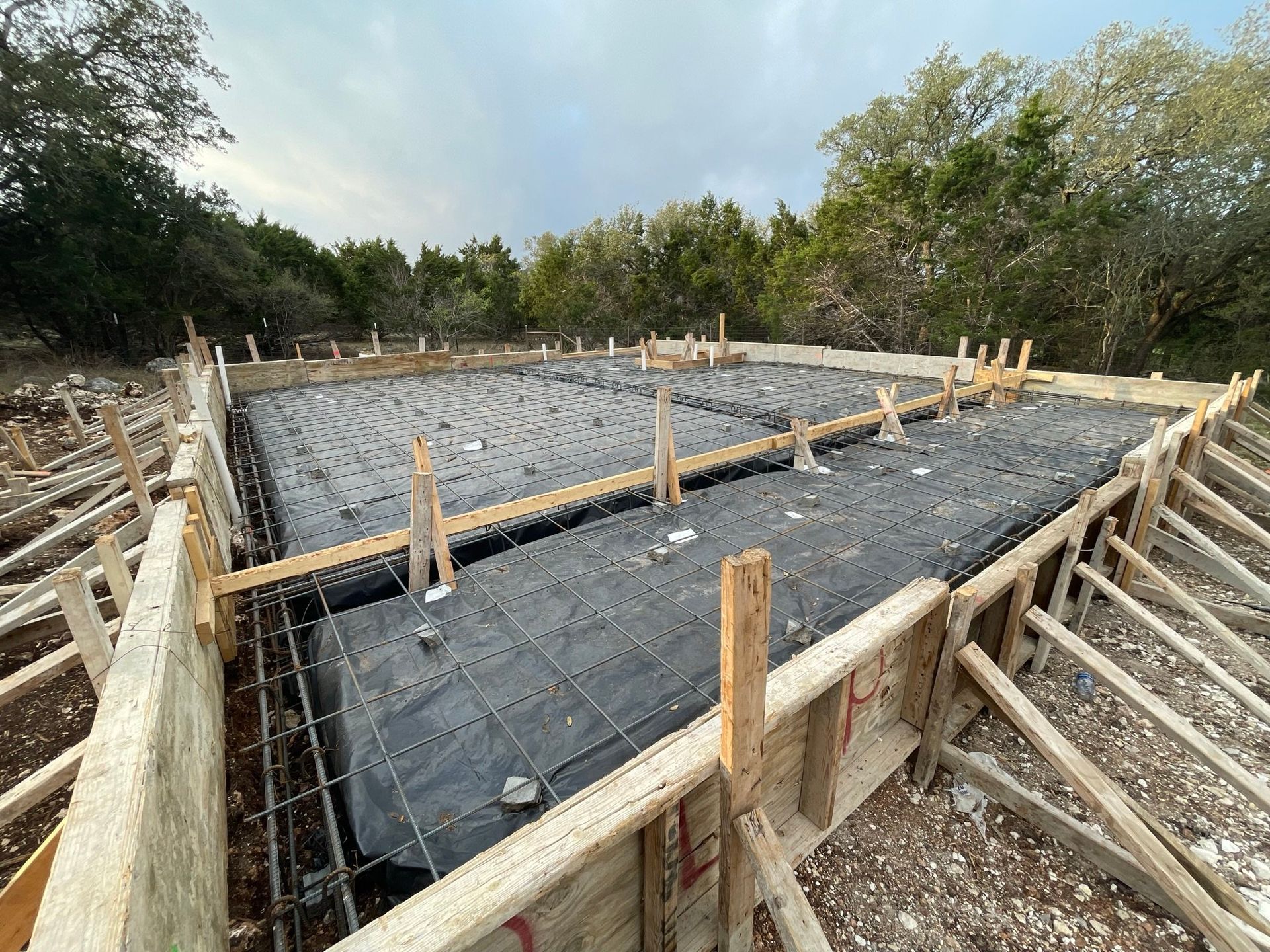 The foundation of a house is being built in the woods.