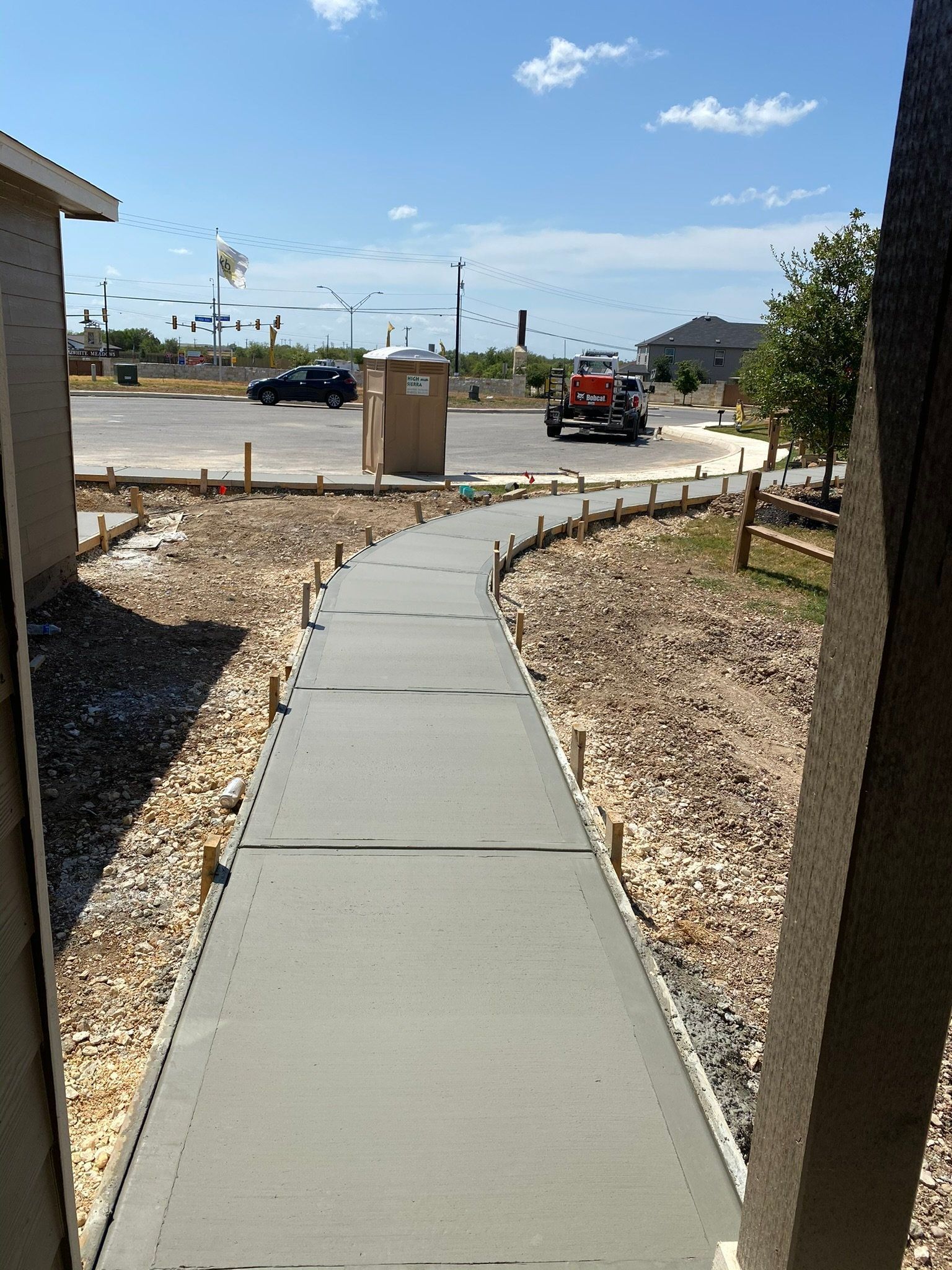 A concrete walkway is being built in a residential area