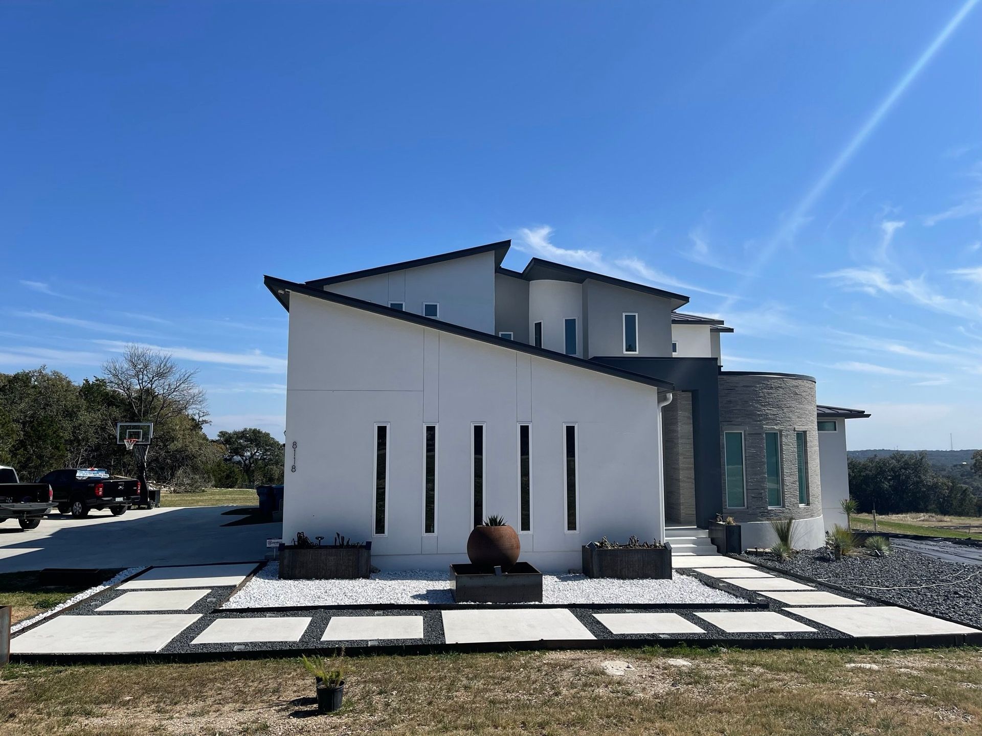 A large white house is sitting on top of a hill.