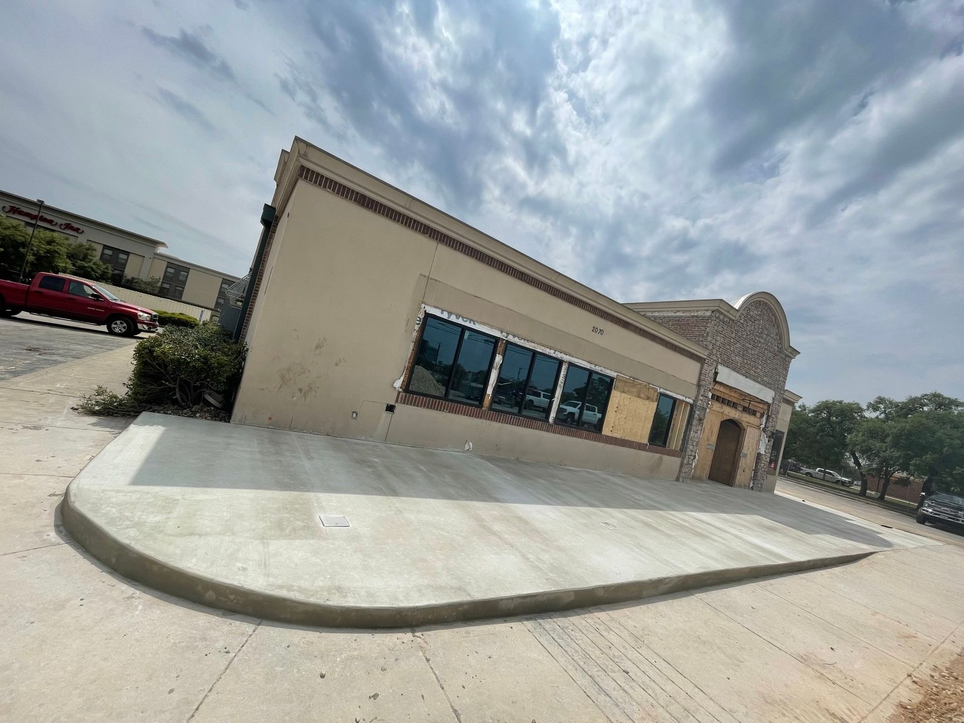 A building with a red truck parked in front of it.