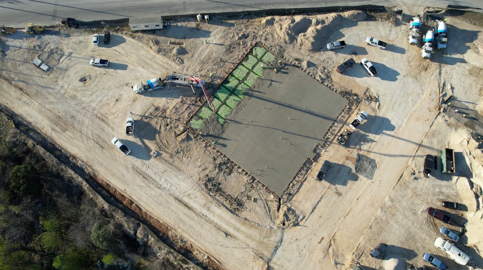 An aerial view of a construction site with concrete being poured on the ground.