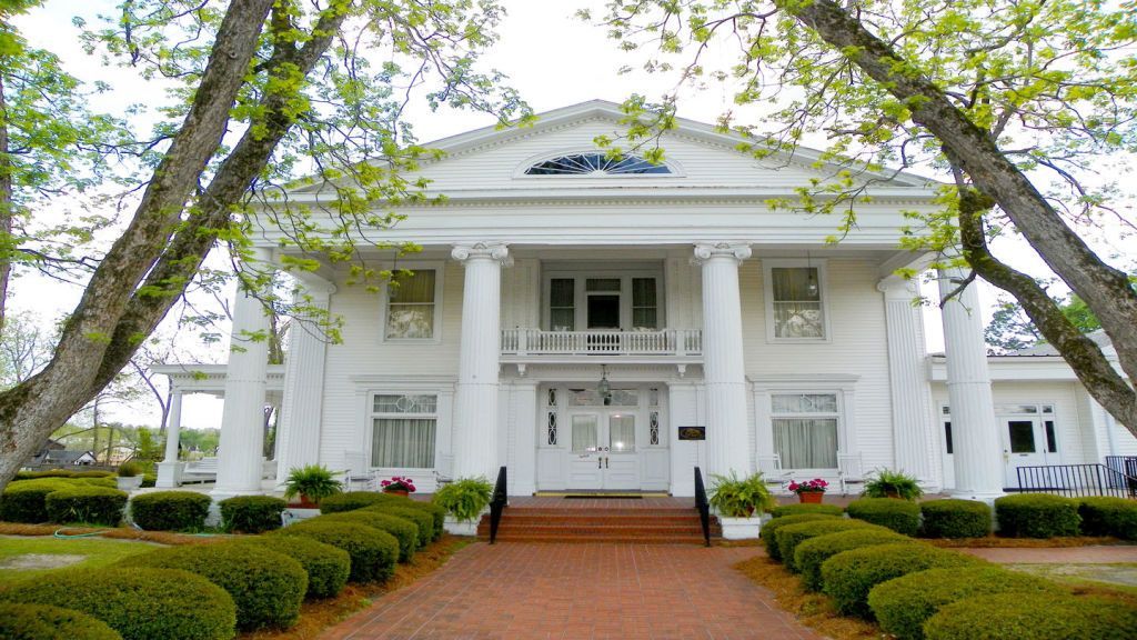 A funeral home with a black awning over the door